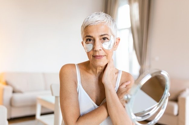 Beauty portrait of middle age woman with wrinkles and a silver patch under eyes Collagen mask and spa concept Copy space Summer skin care