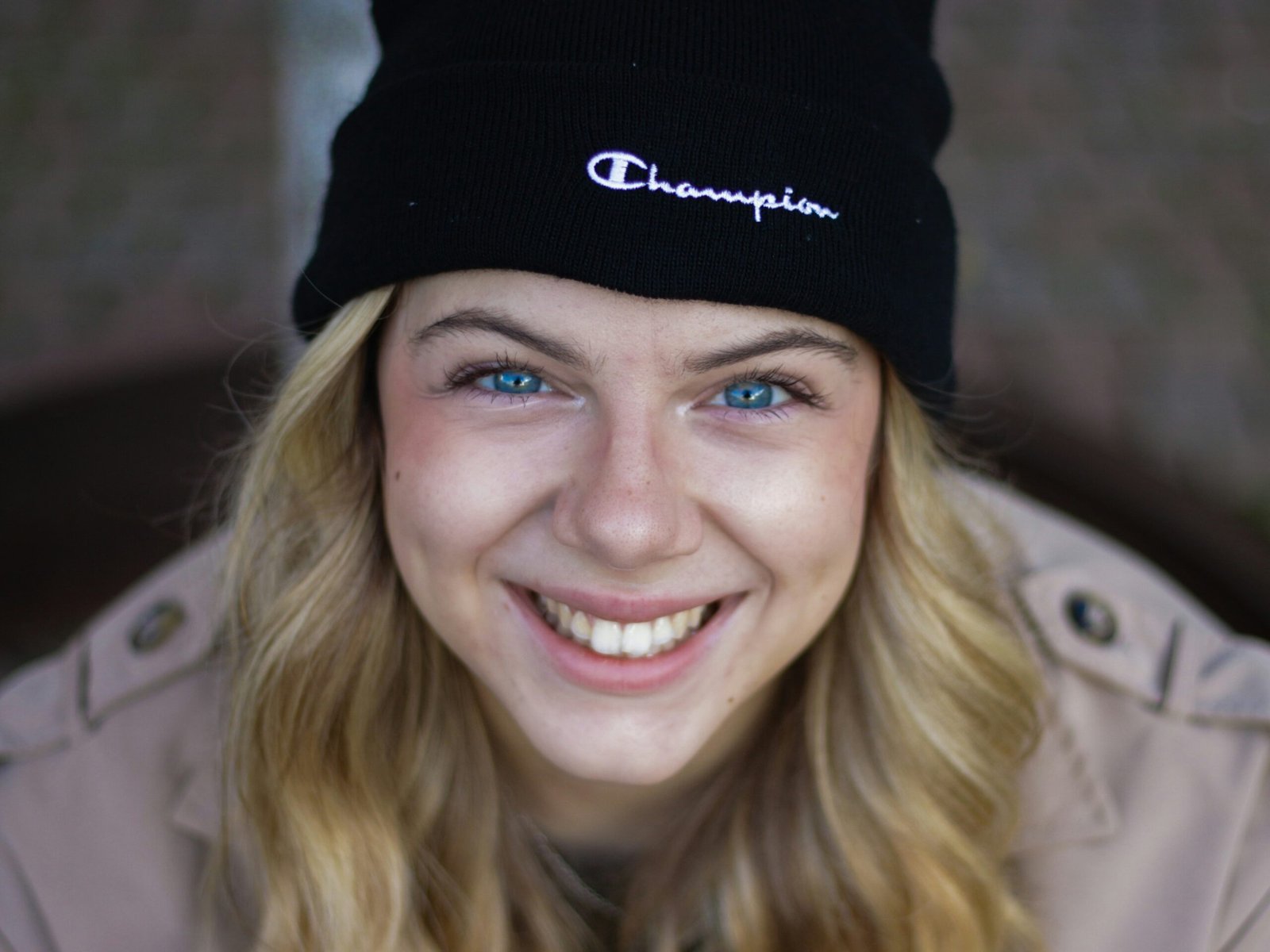 a woman wearing a black beanie smiles at the camera