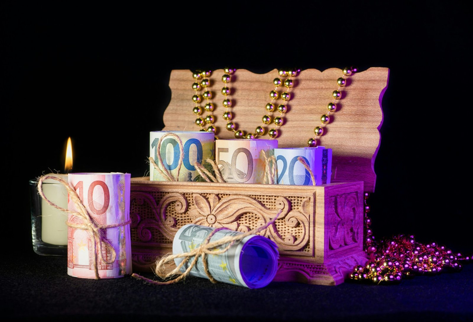 a wooden box with a candle and some beads