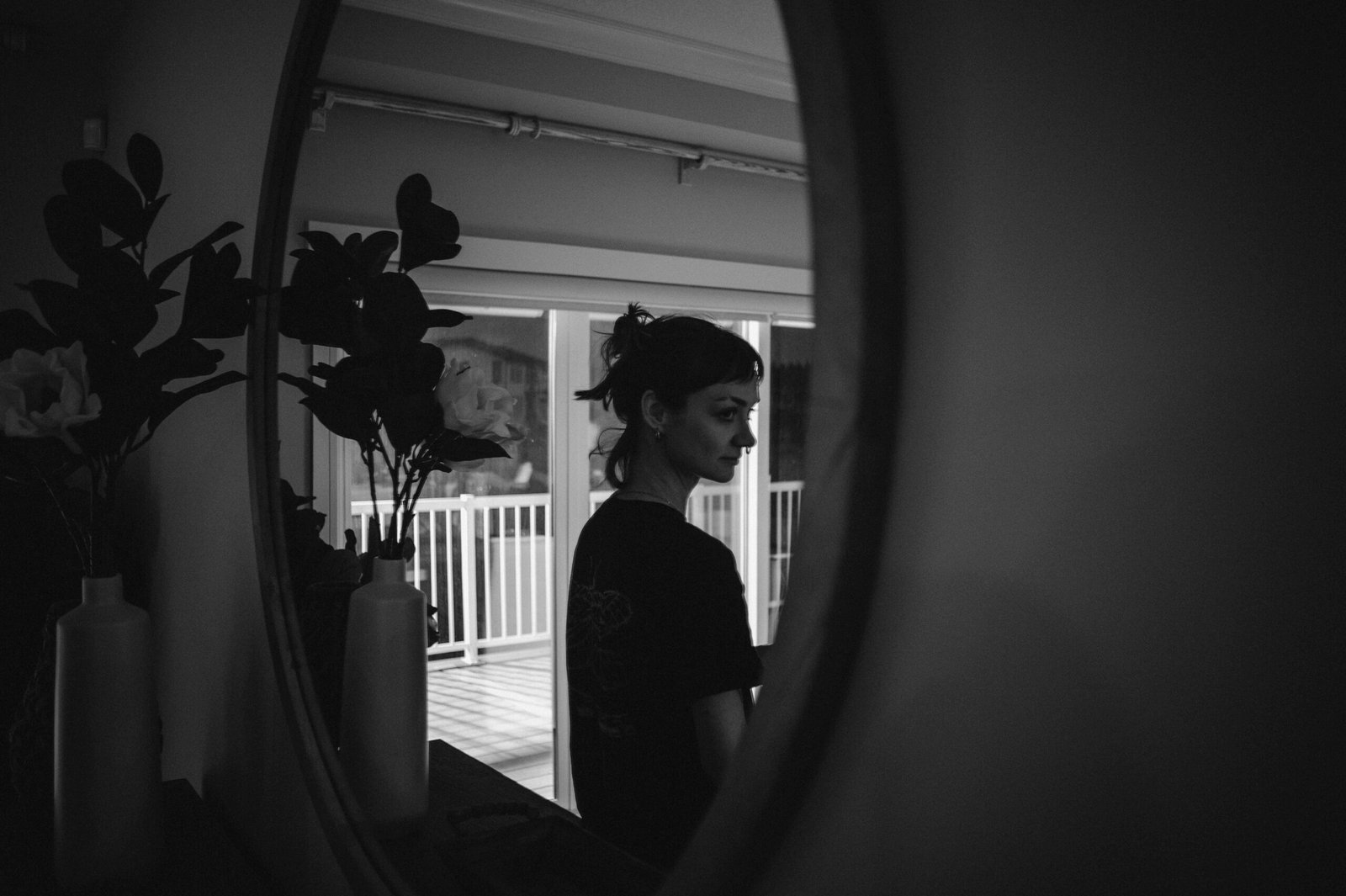 Woman's reflection in an oval mirror indoors