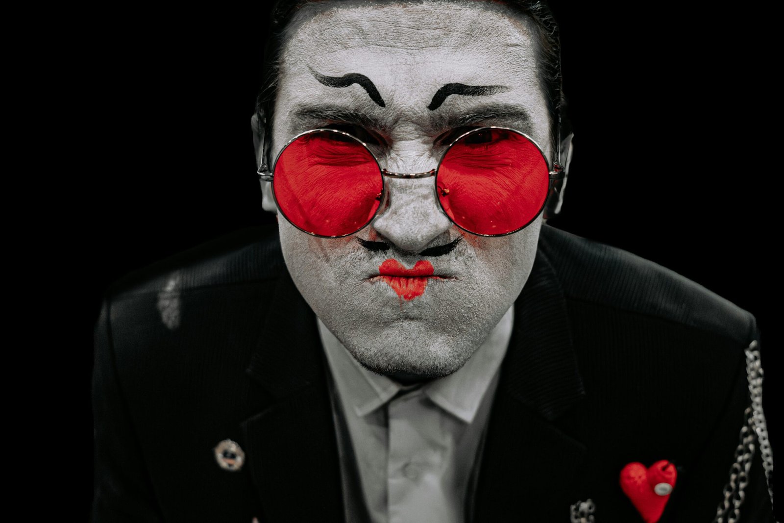 Man with dramatic makeup and red glasses