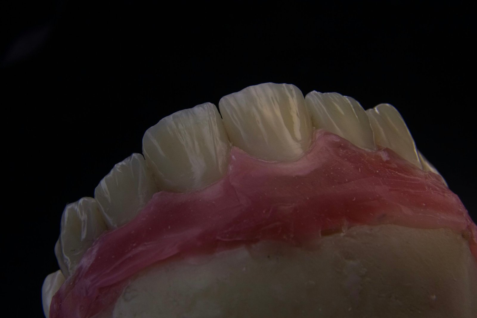 a close up of a tooth with a pink substance on it