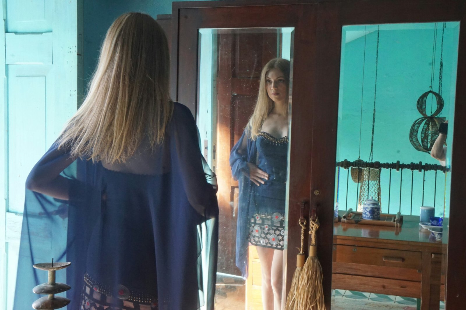 A woman standing in front of a mirror in a room