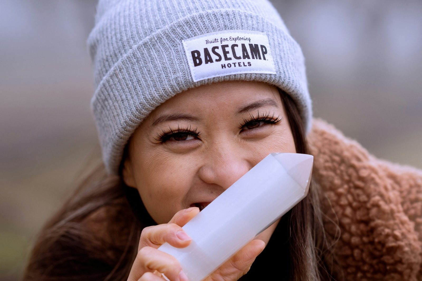 a woman wearing a beanie drinking from a cup