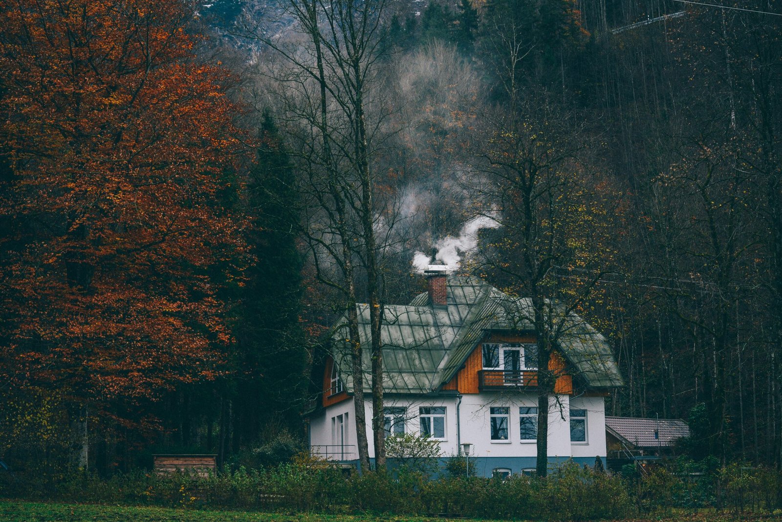 white and brown concrete house surrounded by tree