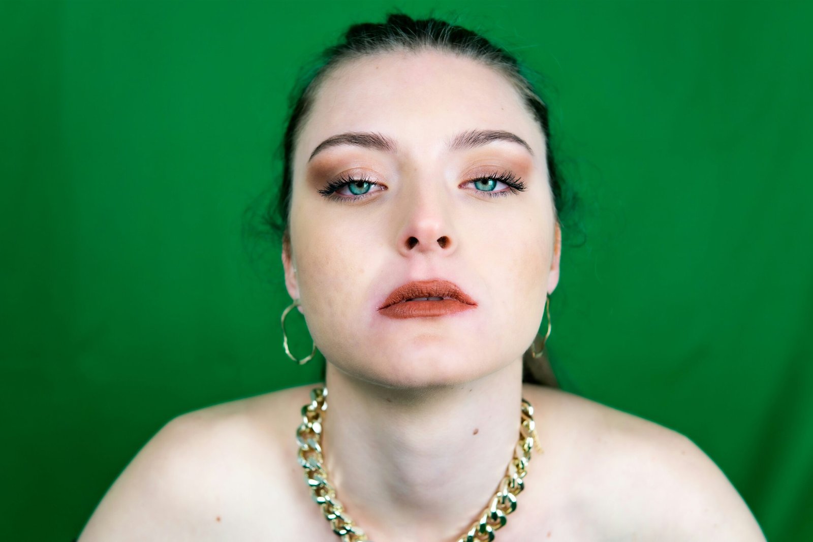 woman in gold necklace and silver earrings