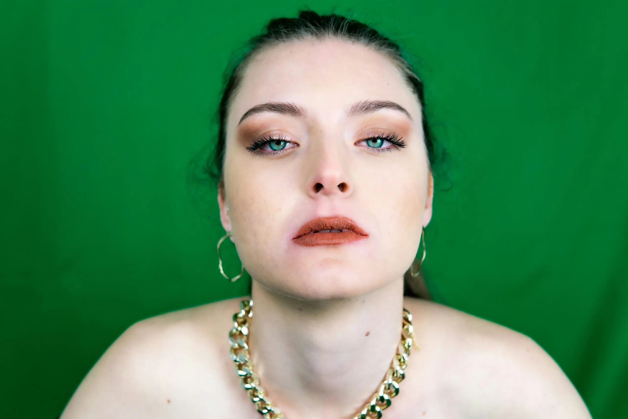 woman in gold necklace and silver earrings