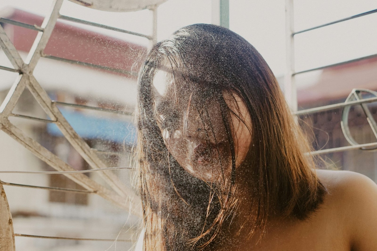 topless woman covering face with hair
