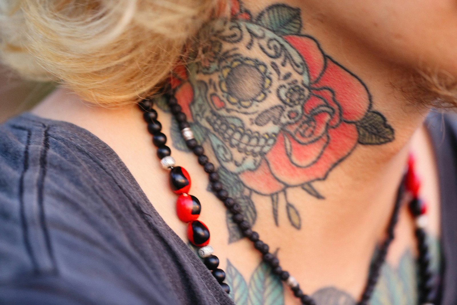 a woman with a skull and rose tattoo on her neck