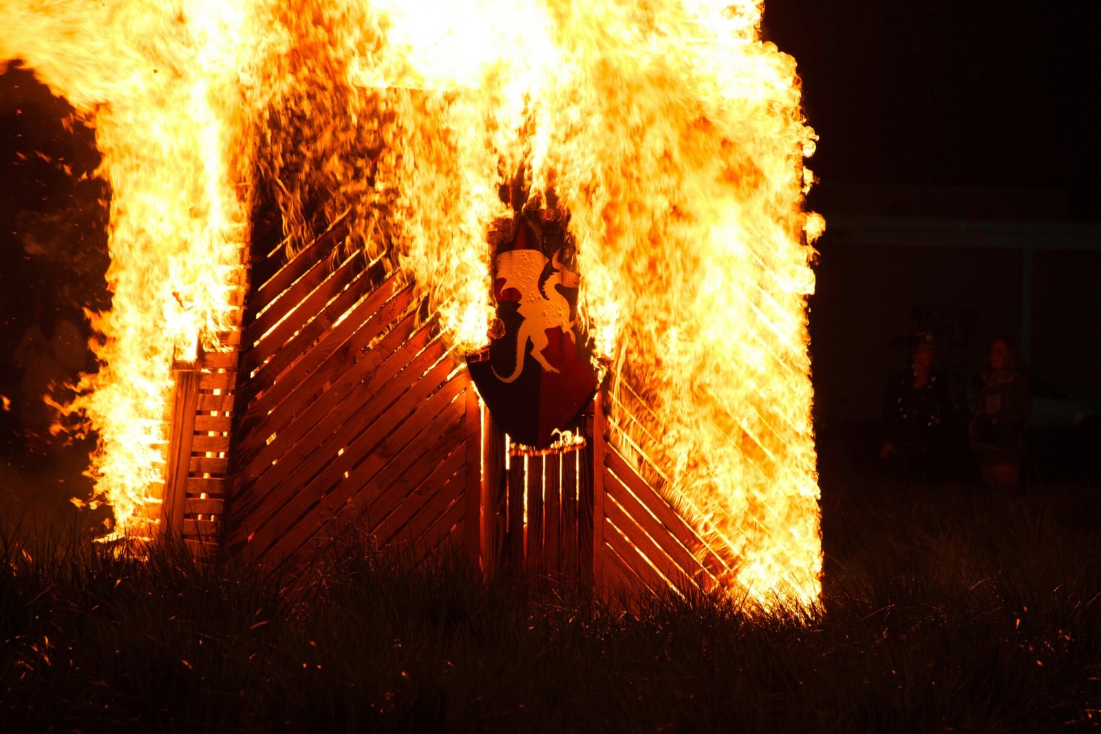 A wooden structure is engulfed in flames.