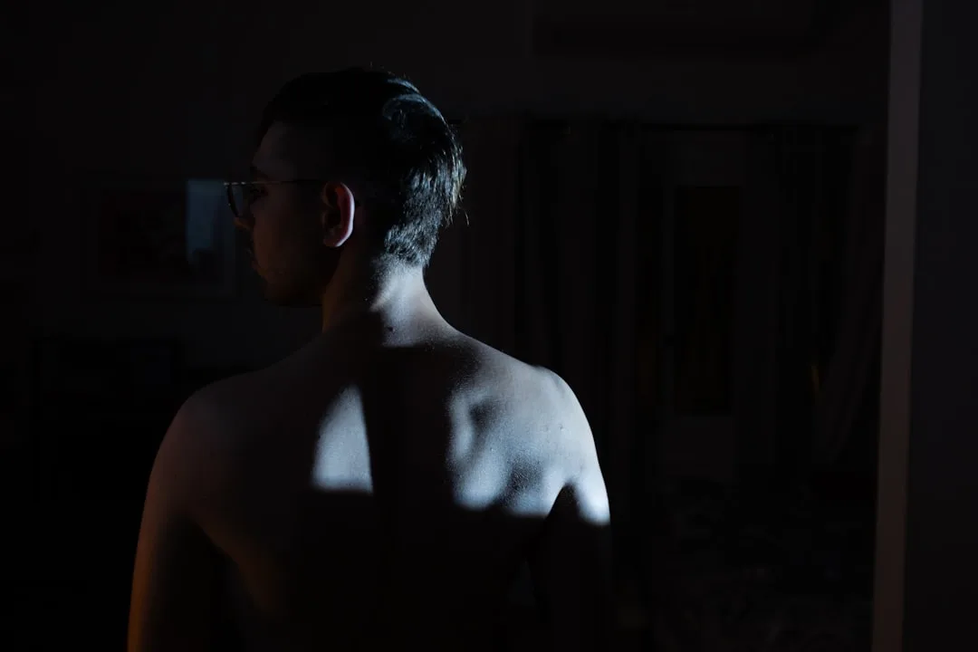 A shadowy man stands in the darkness.
