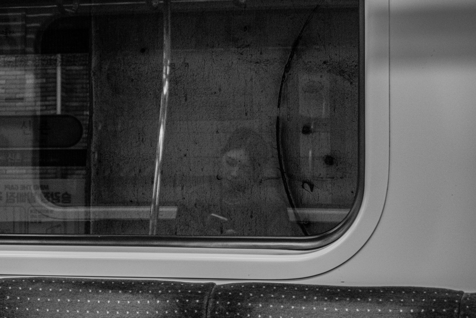 a black and white photo of a window and a seat