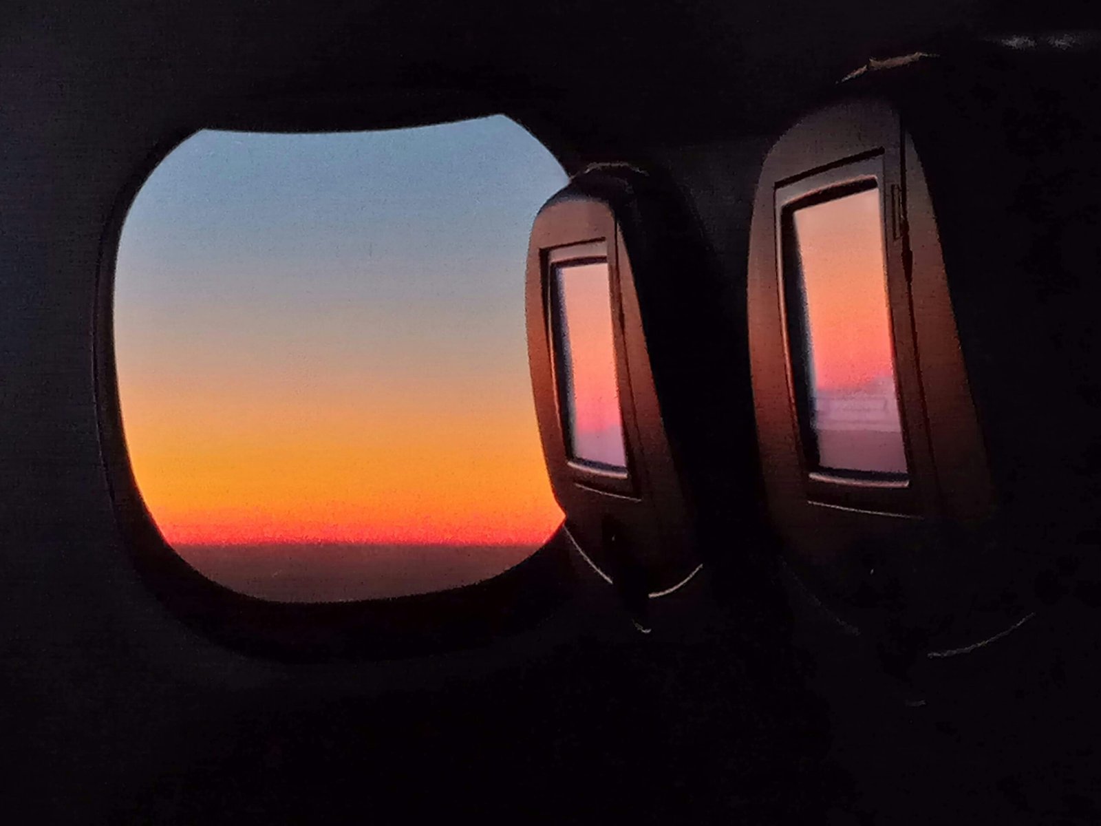 the view out of an airplane window at sunset