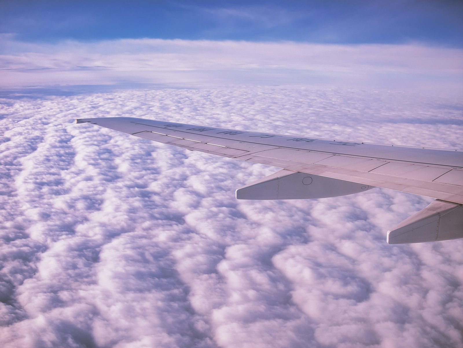 the wing of an airplane flying above the clouds