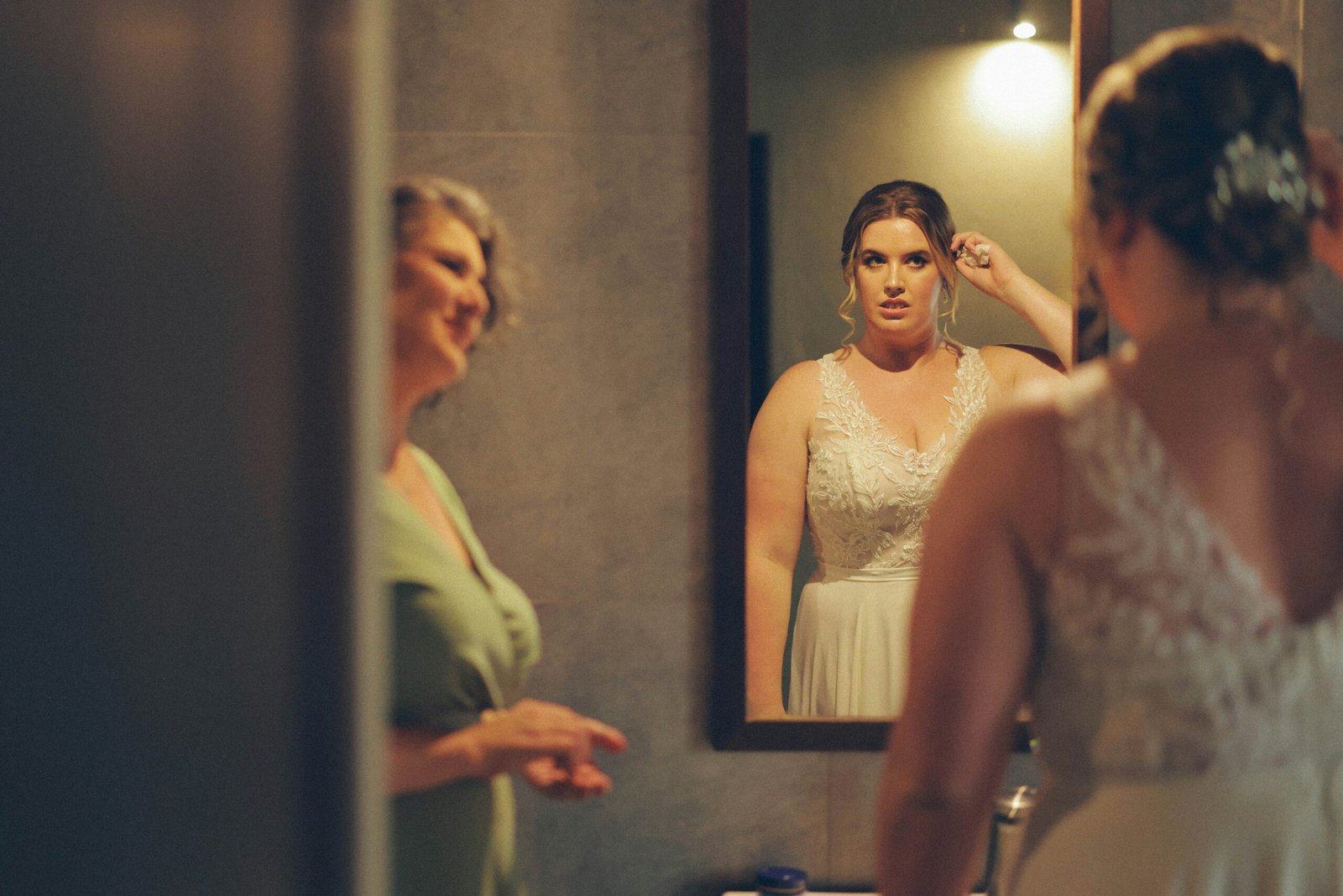 Bride and mother looking in mirror