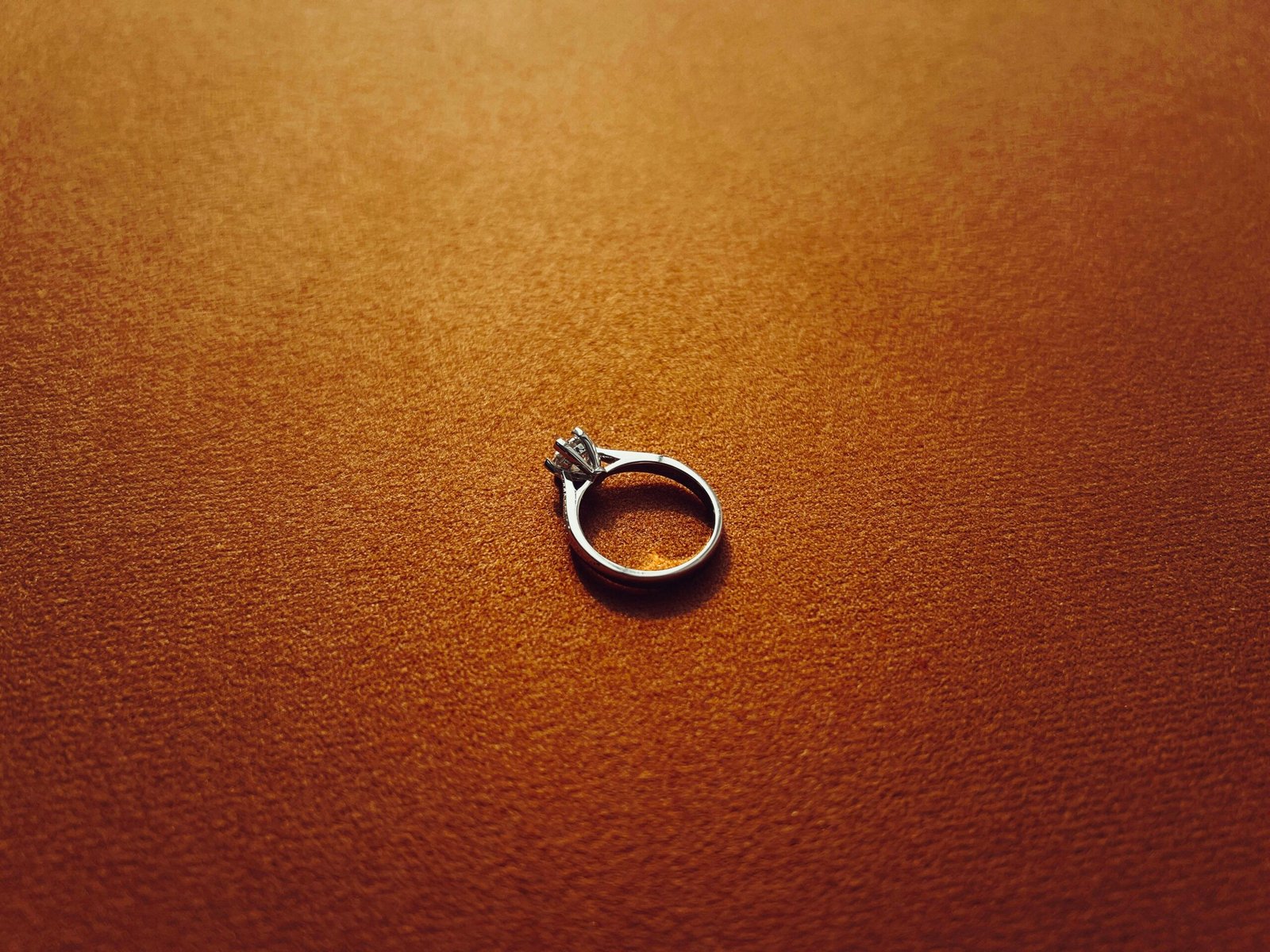 a silver ring sitting on top of a brown surface