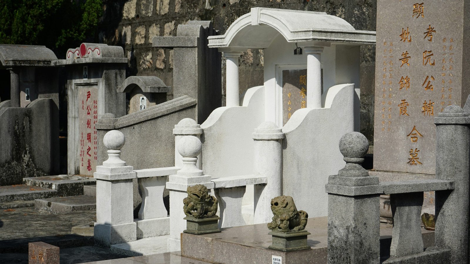 Ornate white tomb with stone lions in cemetery