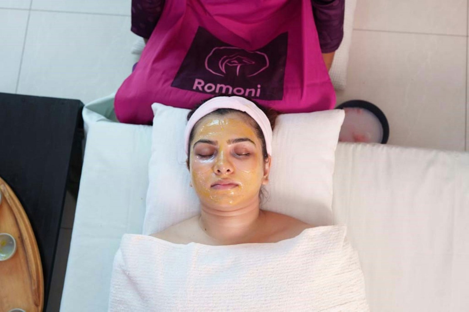 A woman laying in a bed with a towel on her head