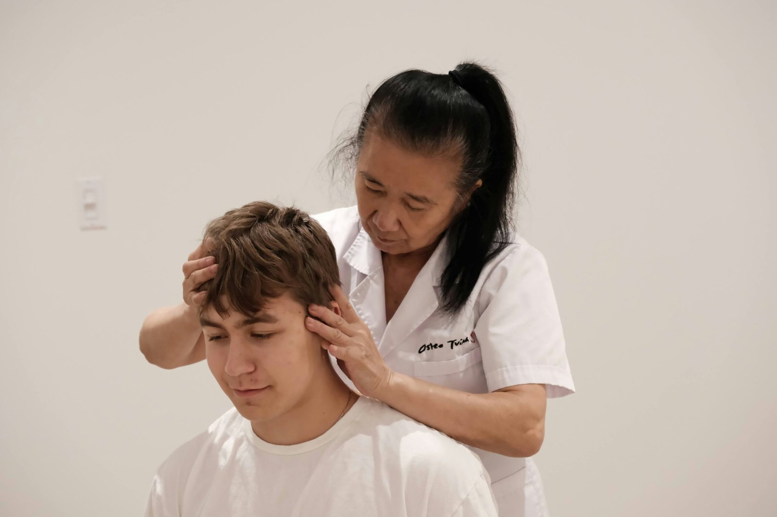 A man getting his hair cut by a woman