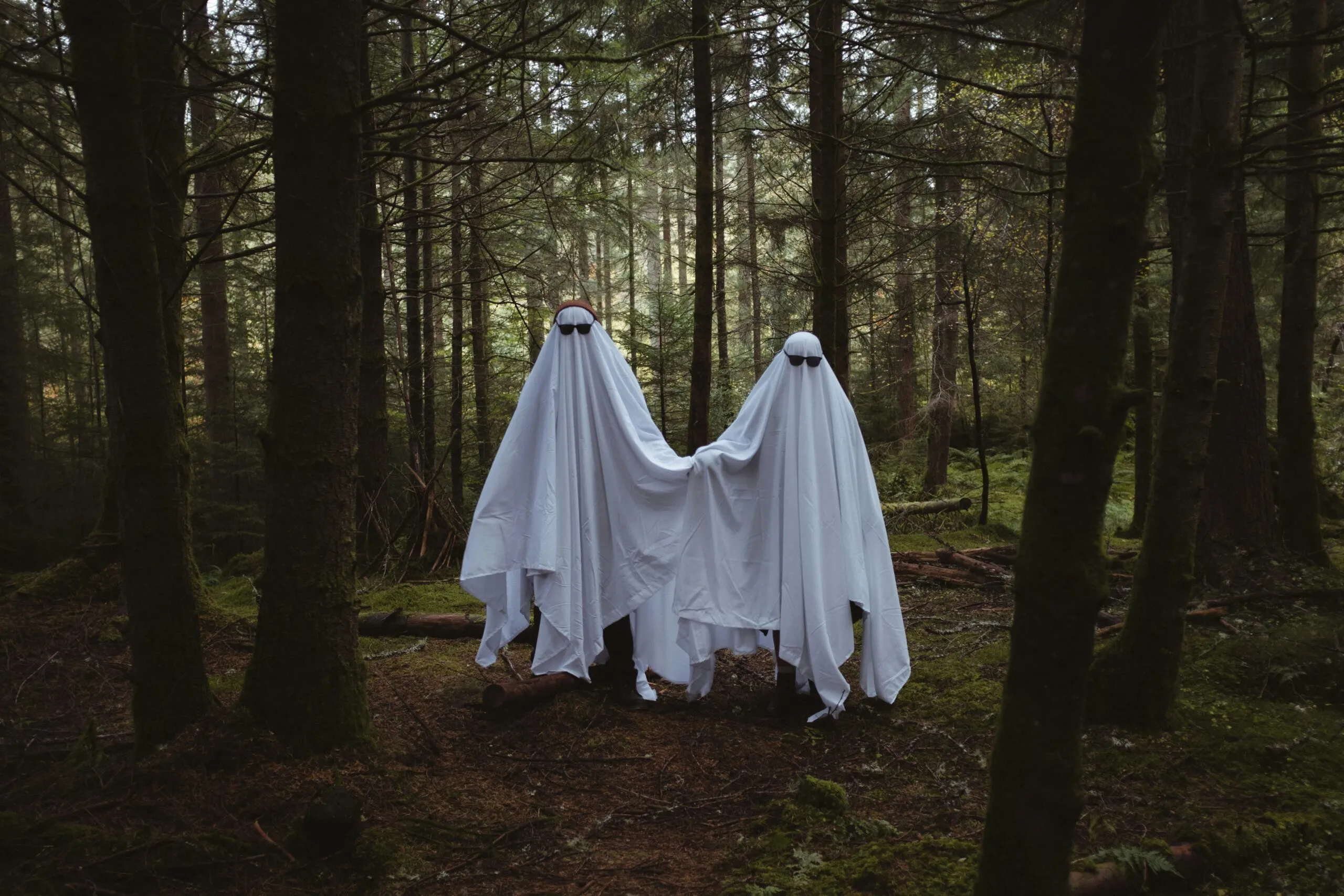 two people in white dresses in a forest