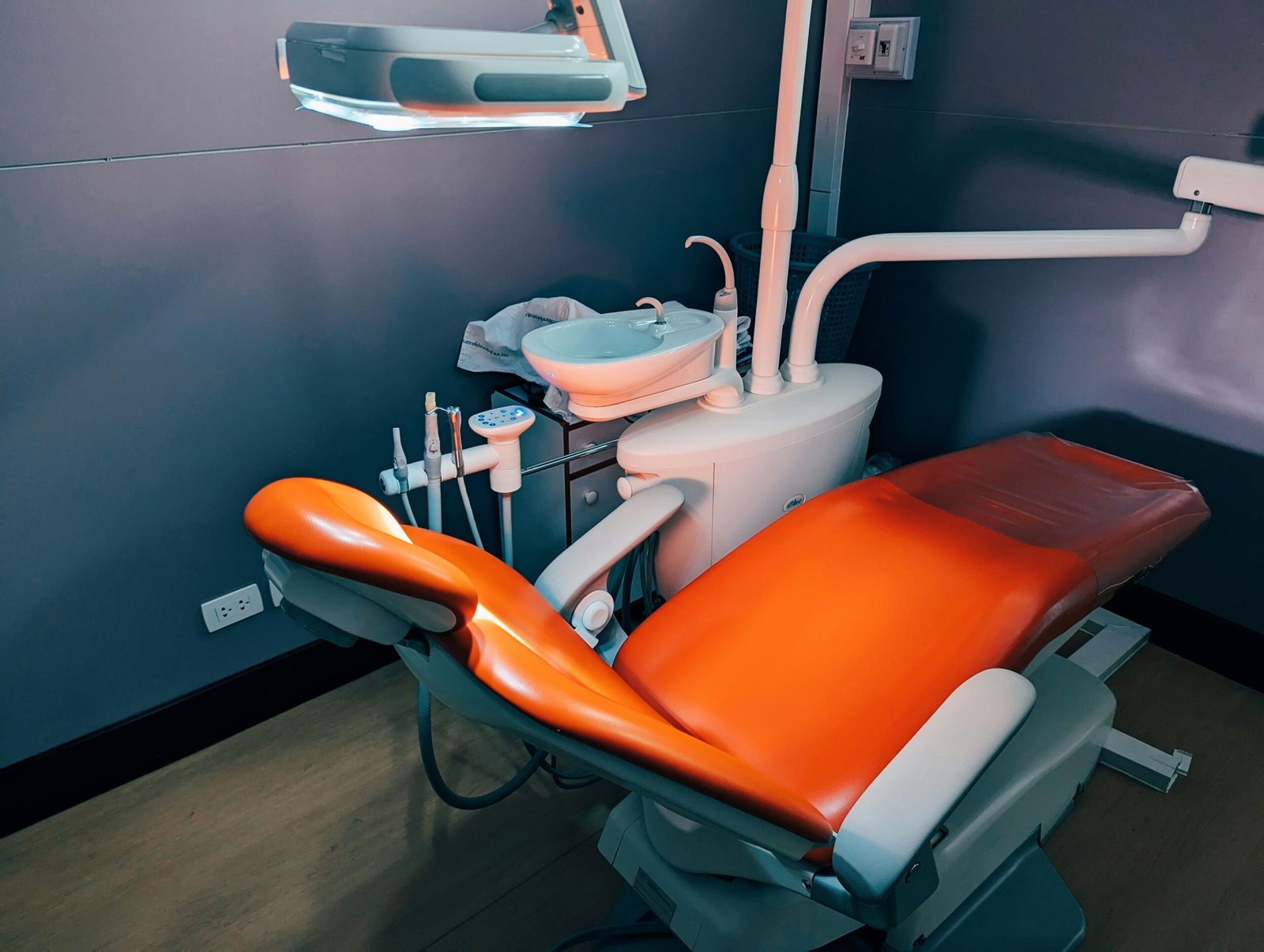 A dental room with a chair and lights