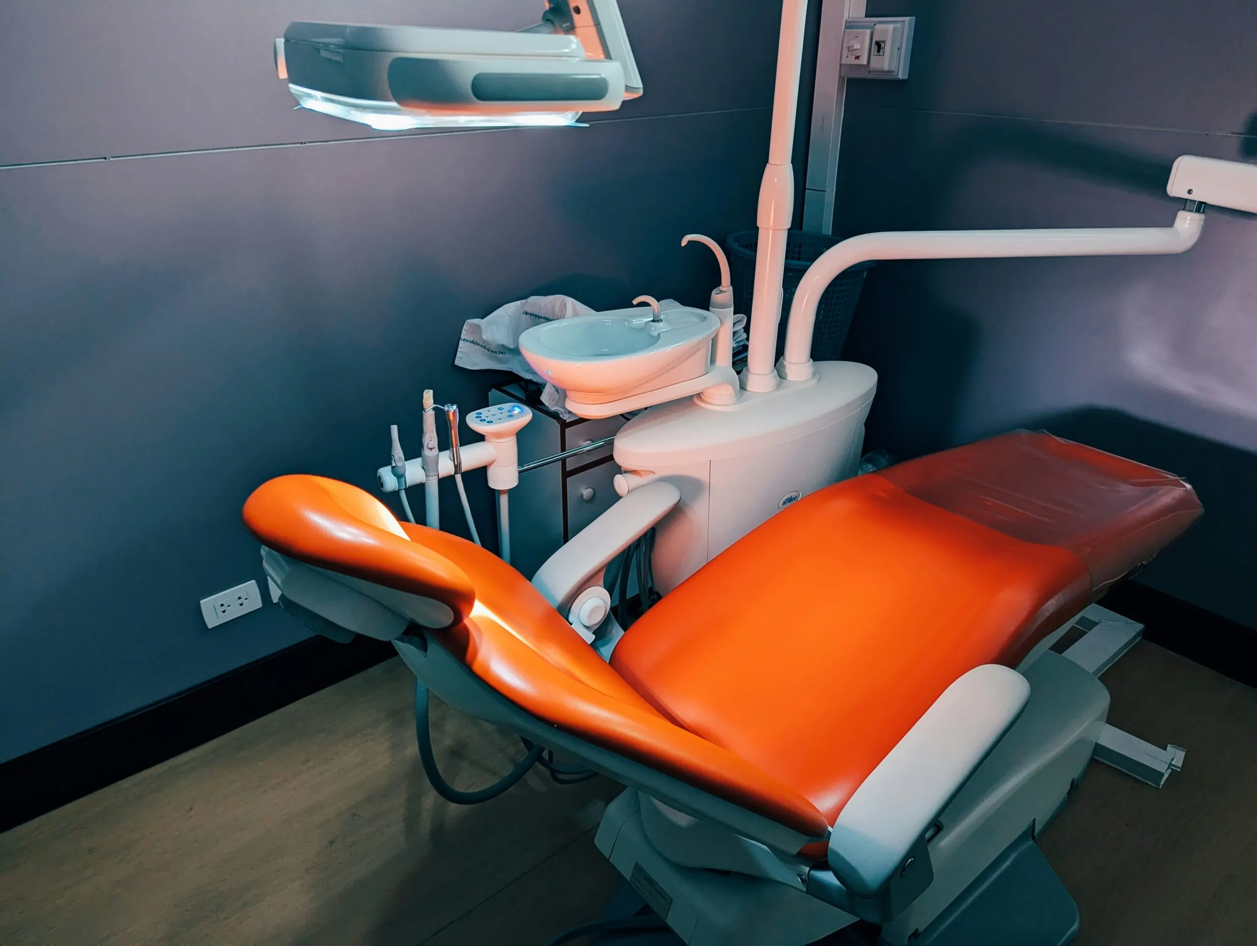 A dental room with a chair and lights
