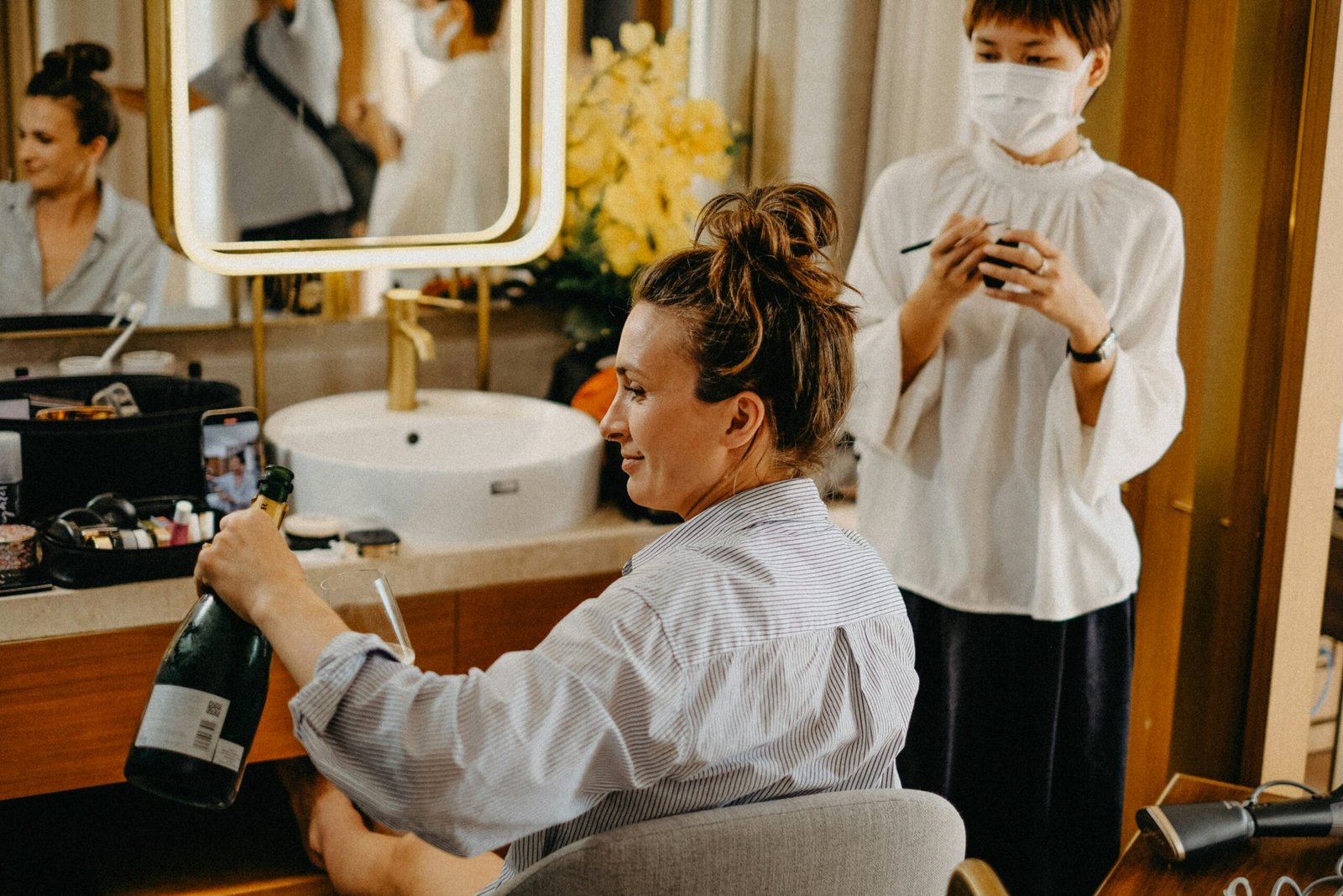 Woman opening champagne bottle while getting ready