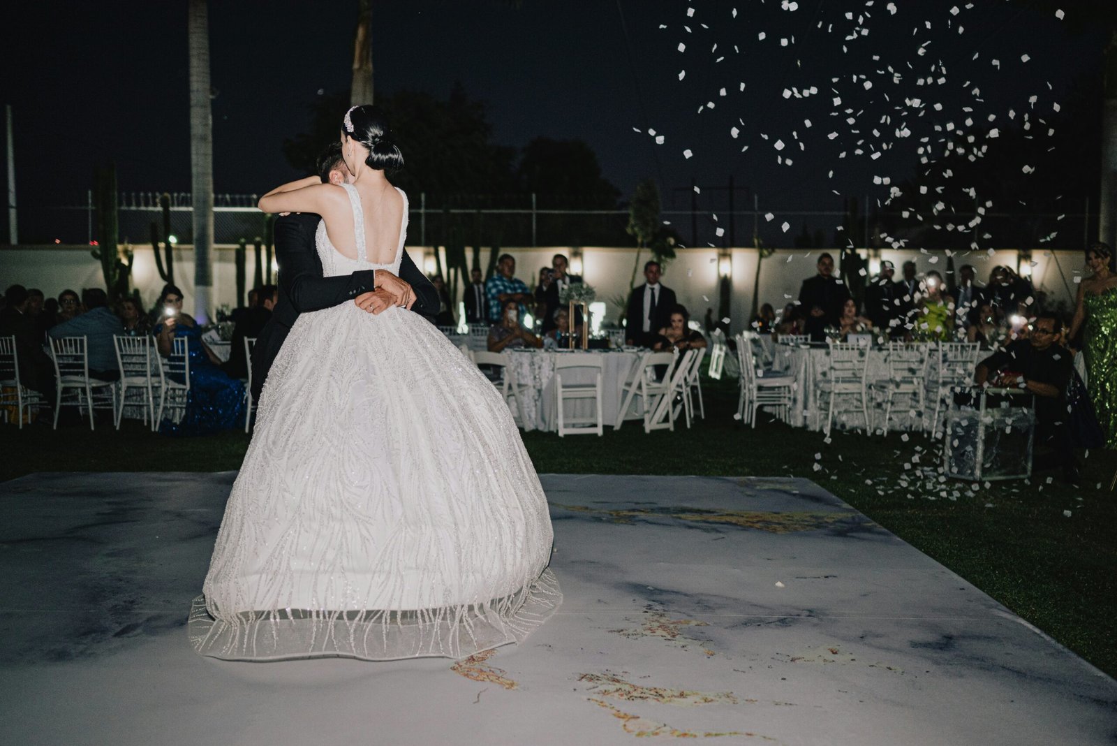 Bride and groom dancing at night wedding reception.