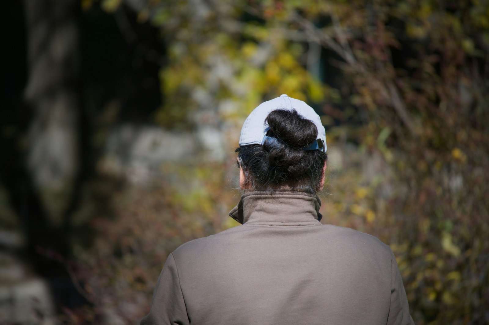 Woman with hair in bun wearing baseball cap