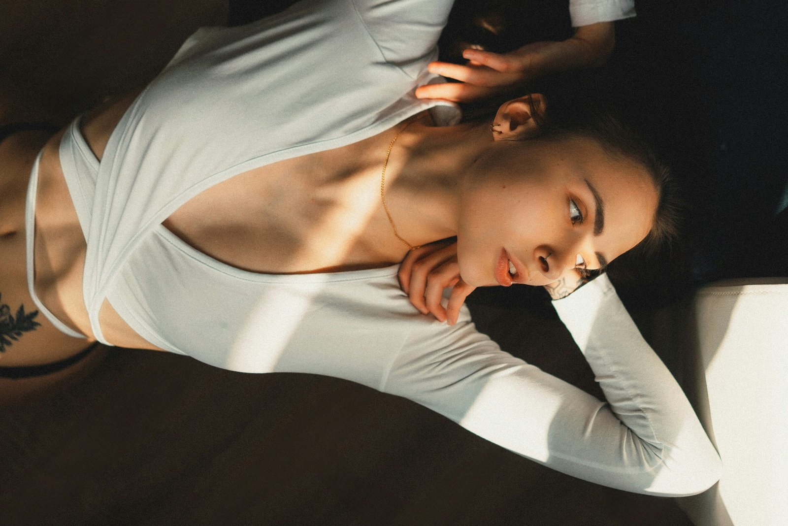 a woman in a white top is laying on the floor