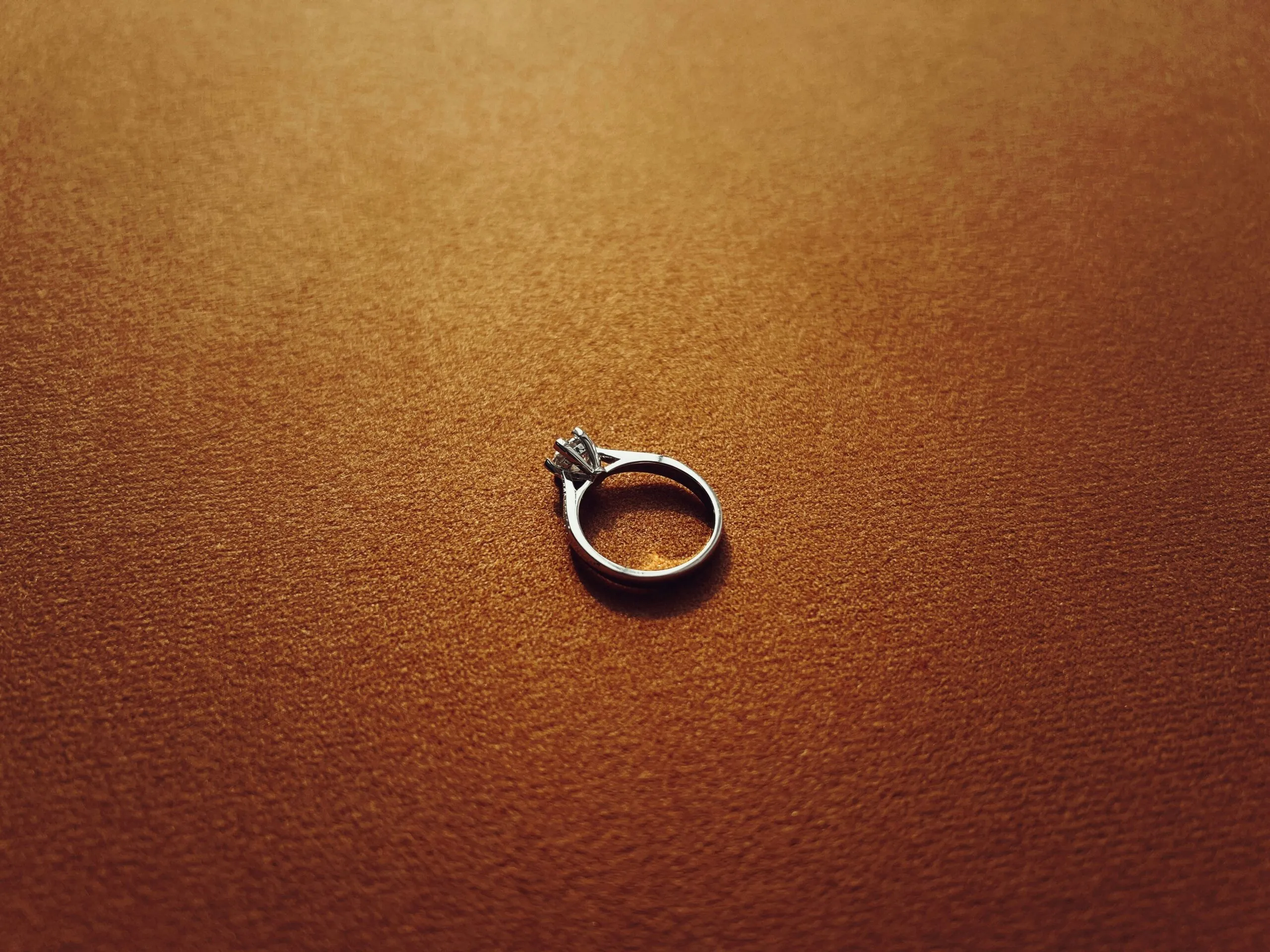 a silver ring sitting on top of a brown surface