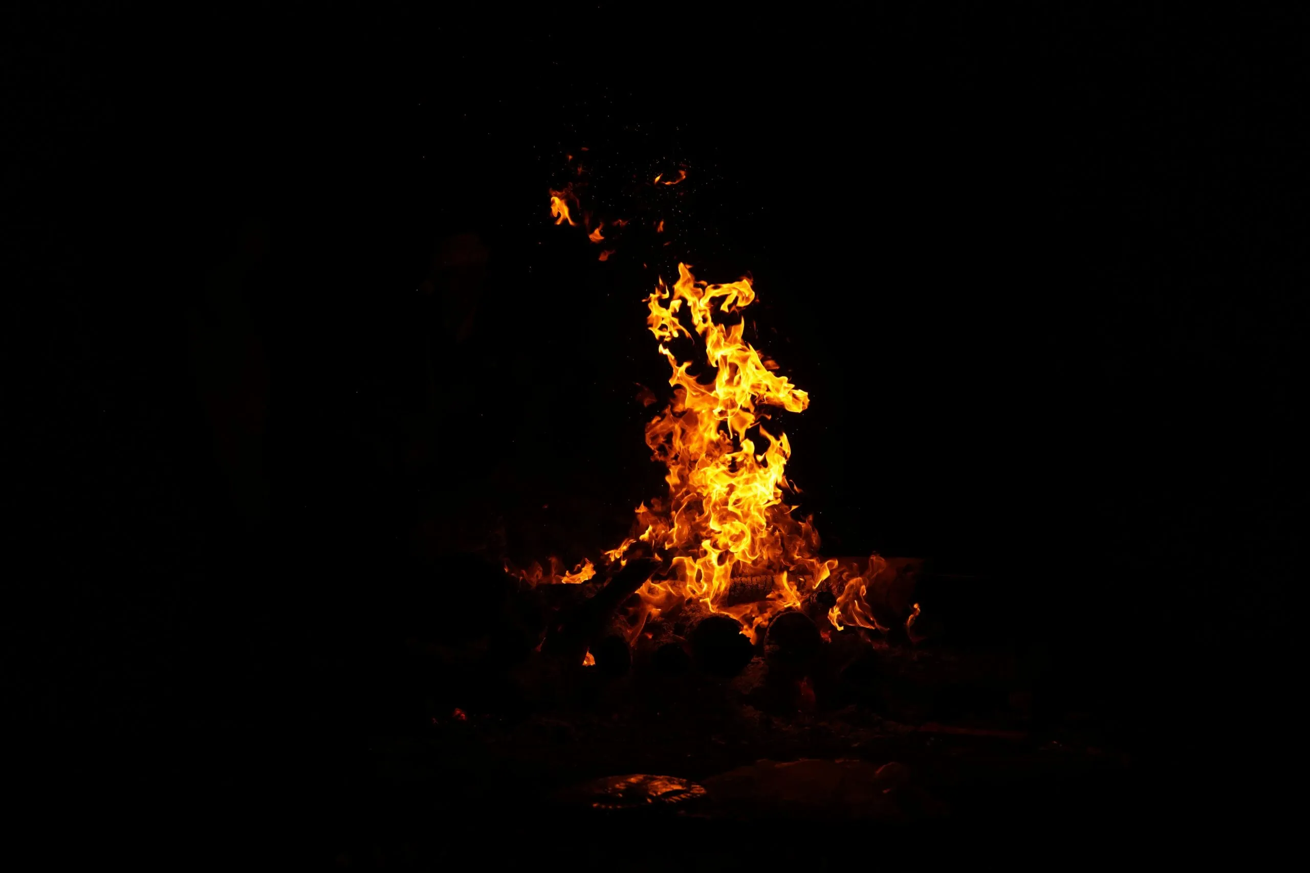 A large fire is burning in the dark