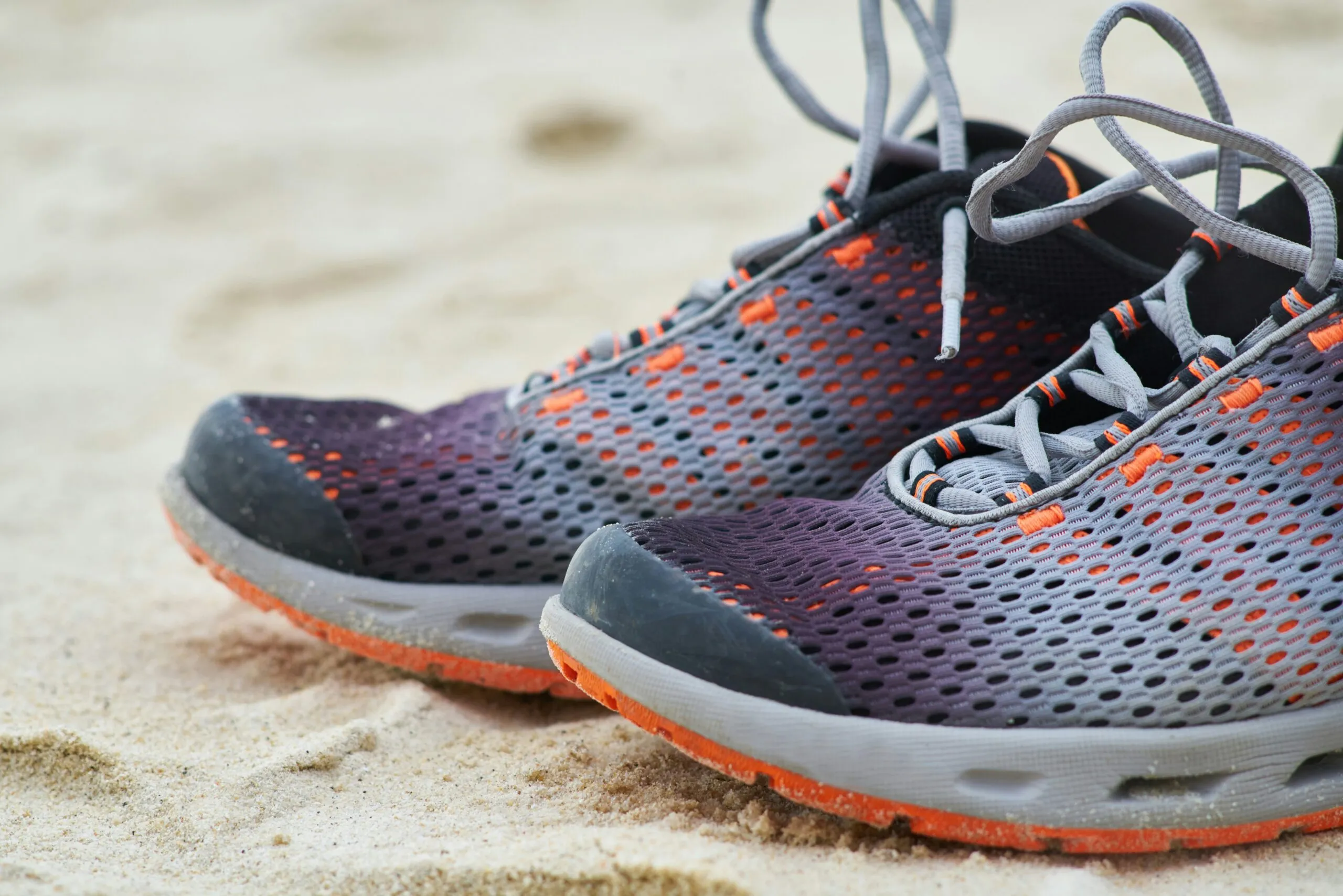 black and white nike athletic shoe on brown sand