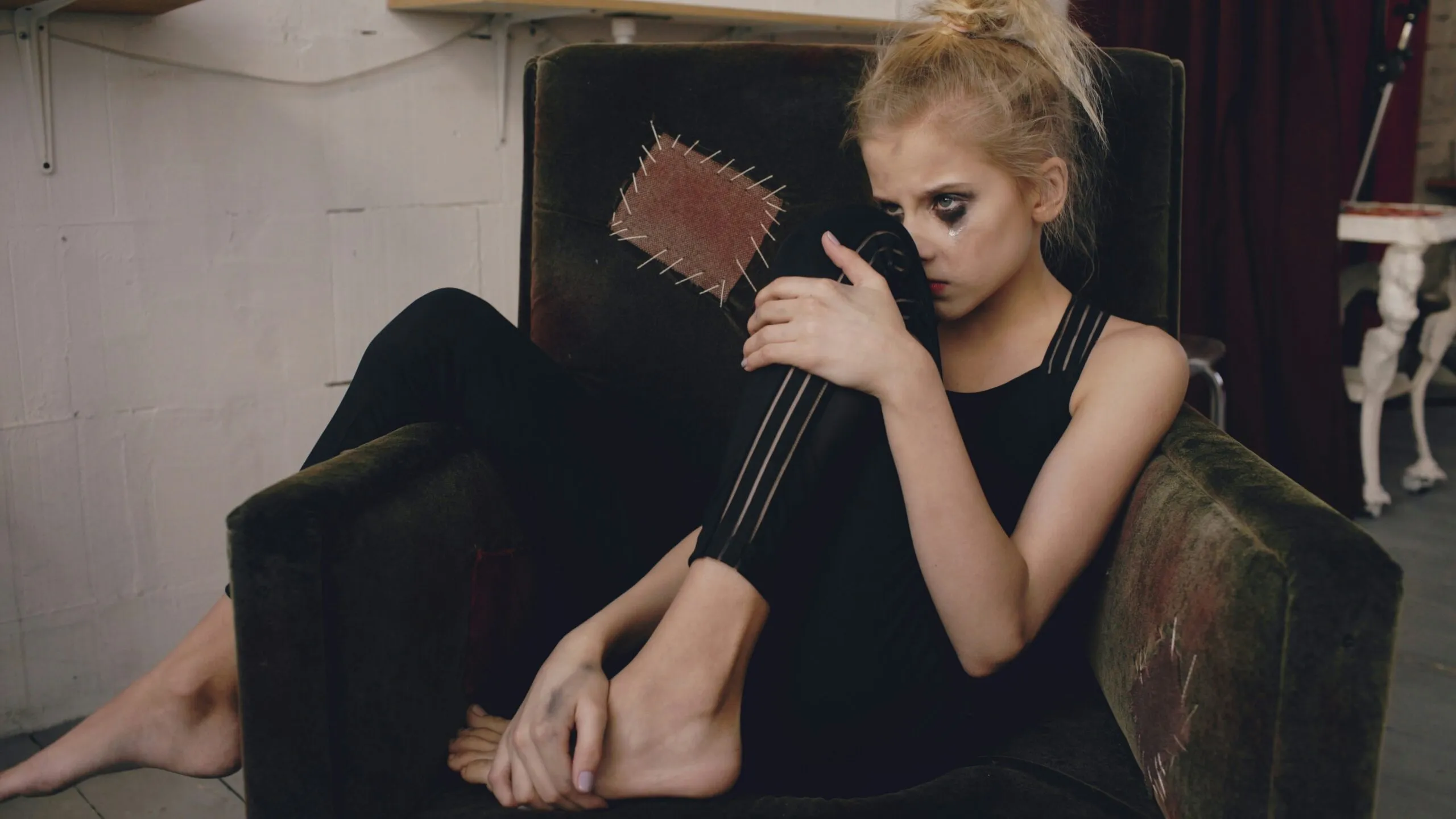 Young woman in black clothing sitting in armchair