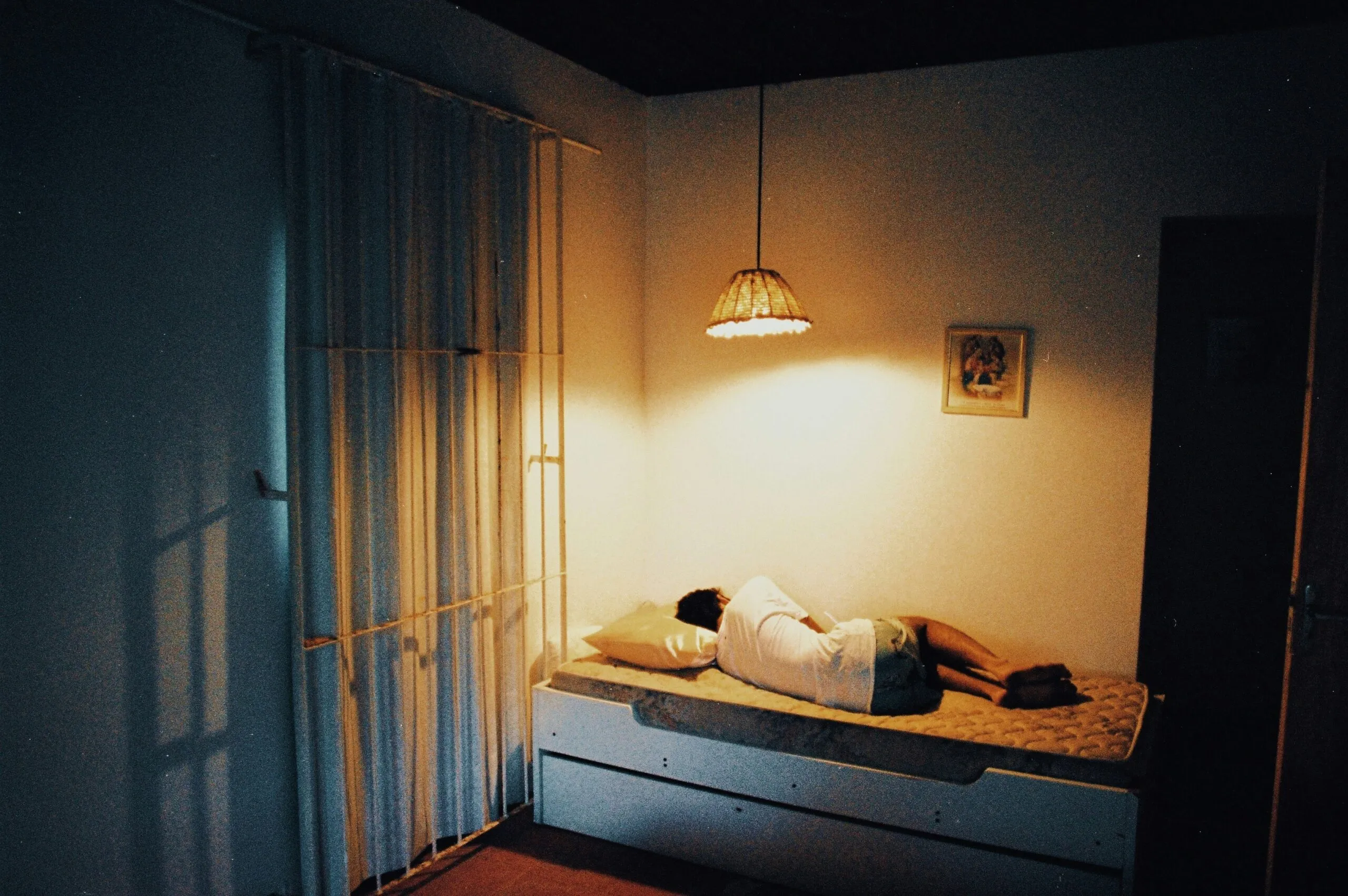 white bed beside white window curtain