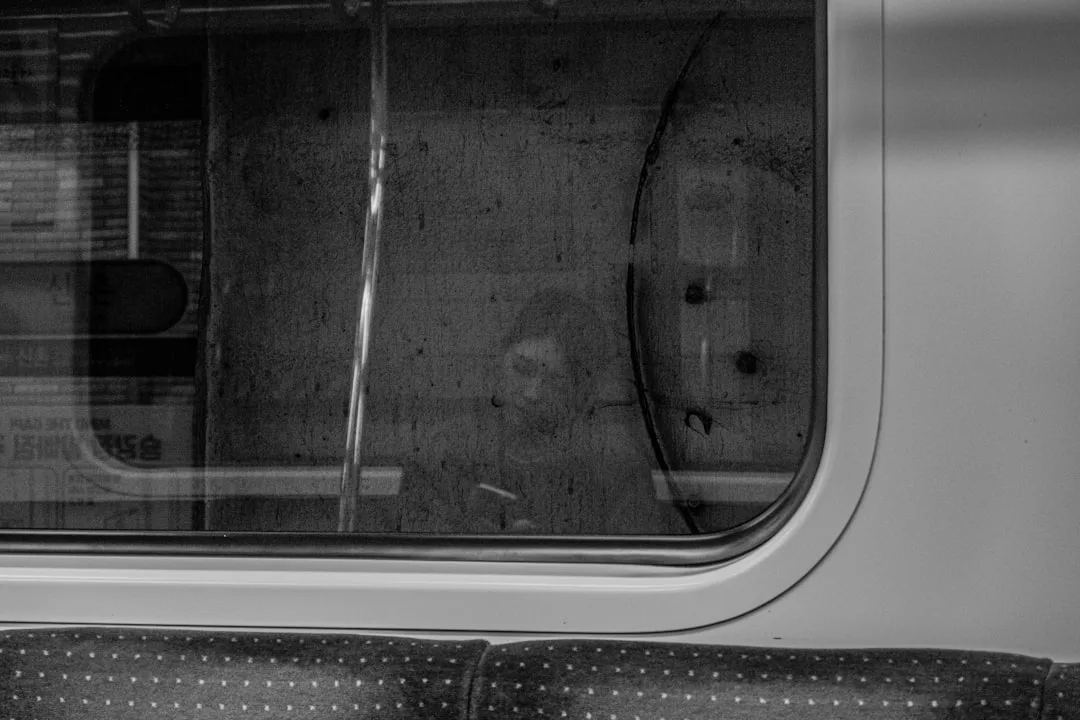 a black and white photo of a window and a seat