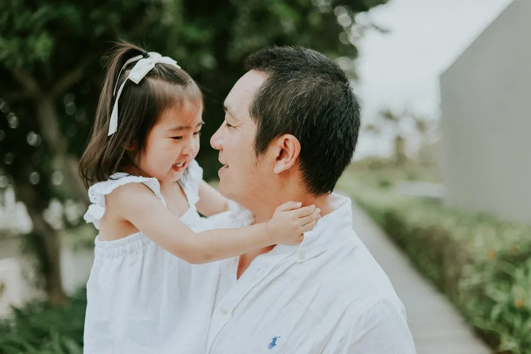 Father holds his young daughter outdoors