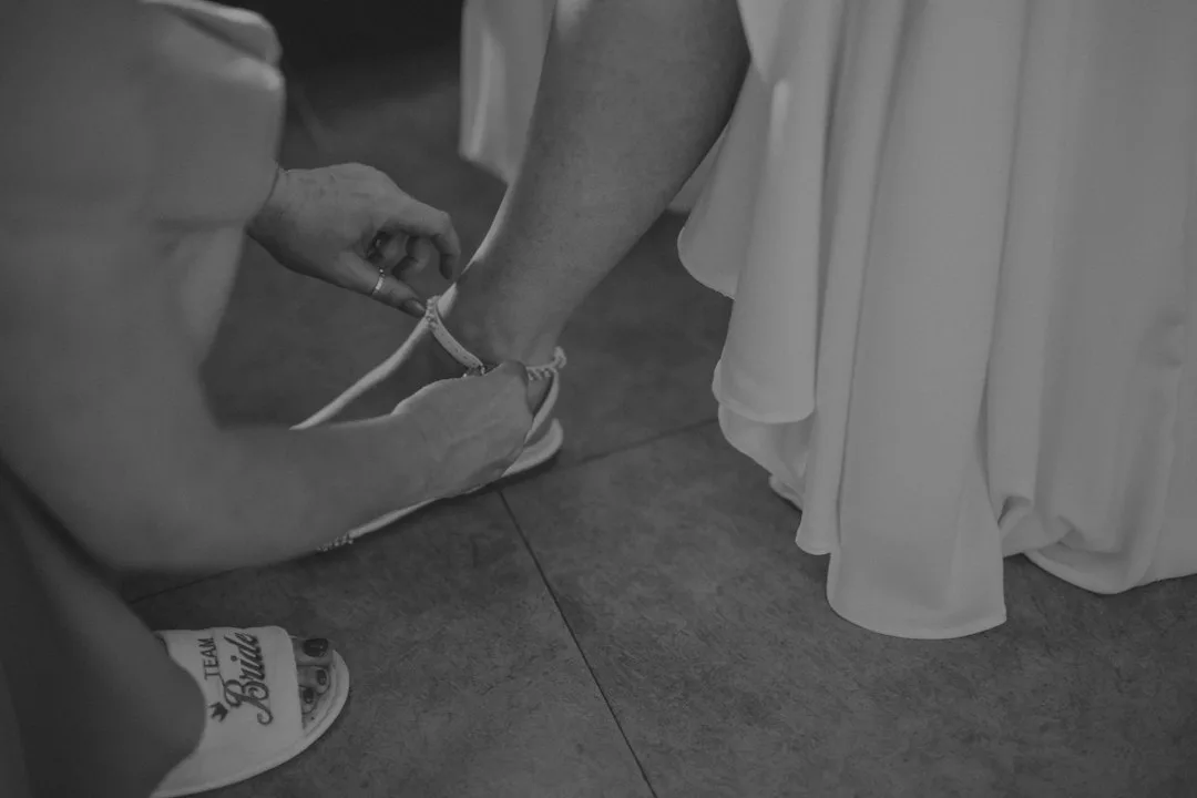 Hands tying a shoe on a person's foot.