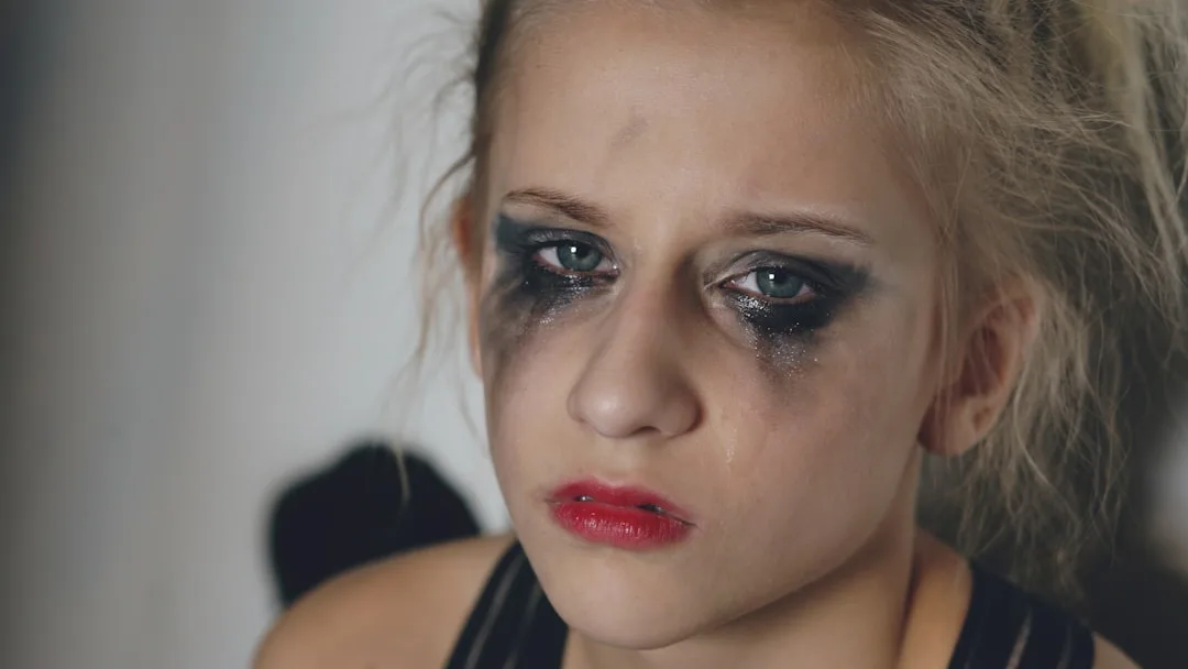 Young girl with smudged makeup and red lipstick