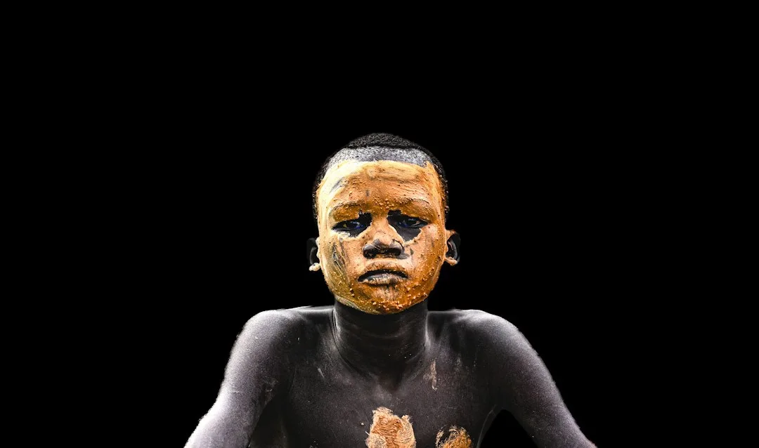 A person covered in muddy pigment.