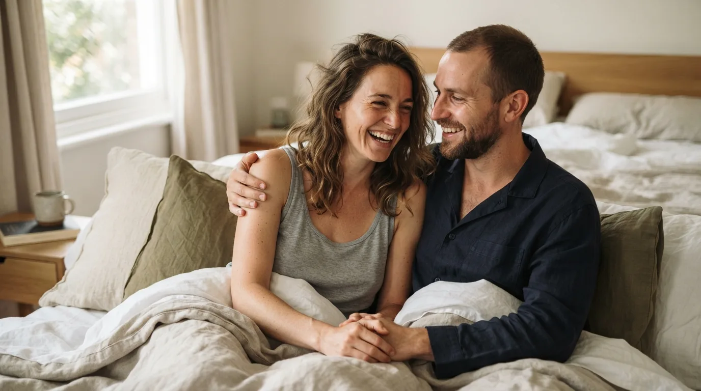 a couple smiling in bed in the morning