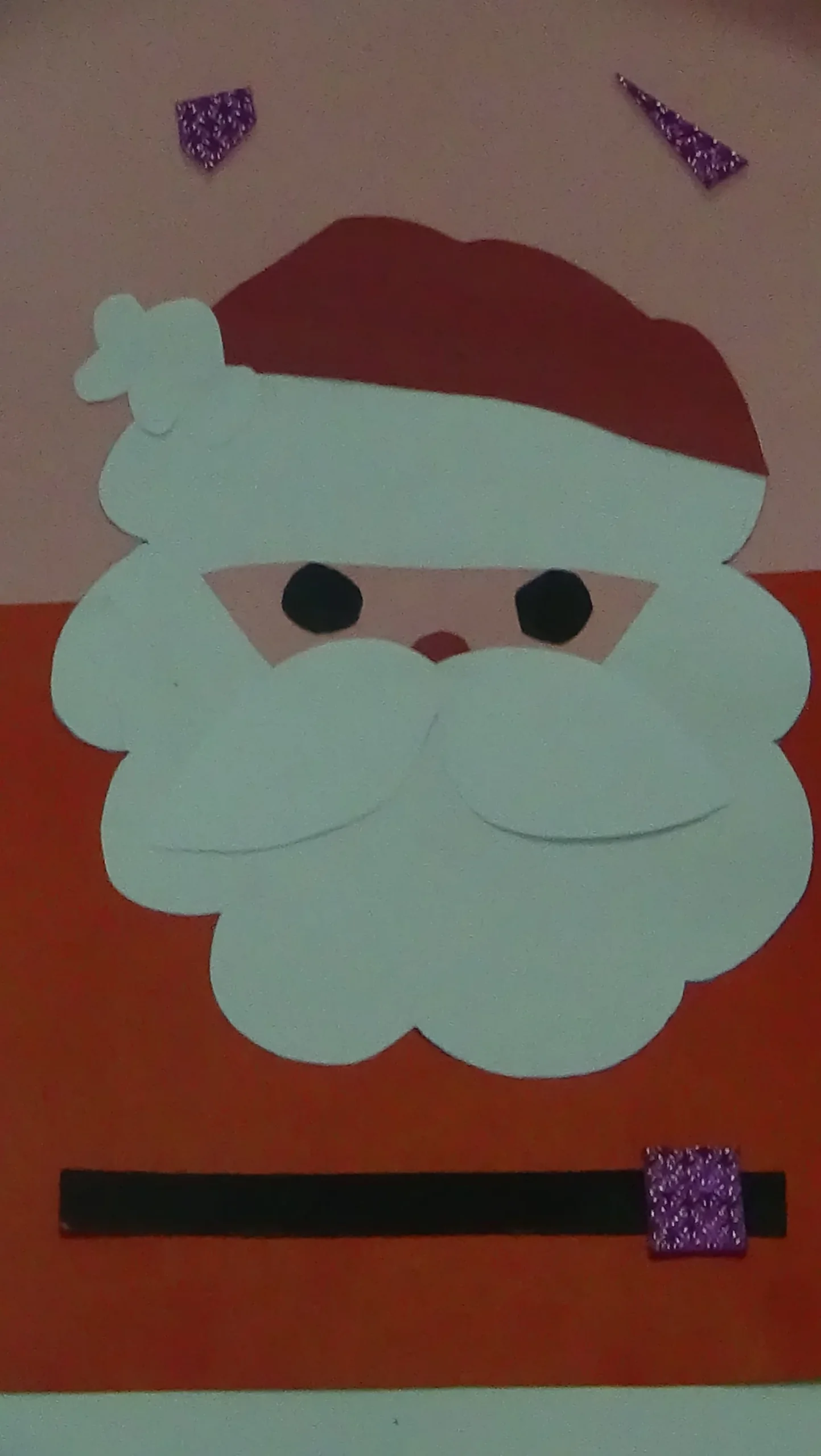 The image is a handmade Christmas card having the beautiful face of Santa Claus with white beard and mustache, red dress and red cap