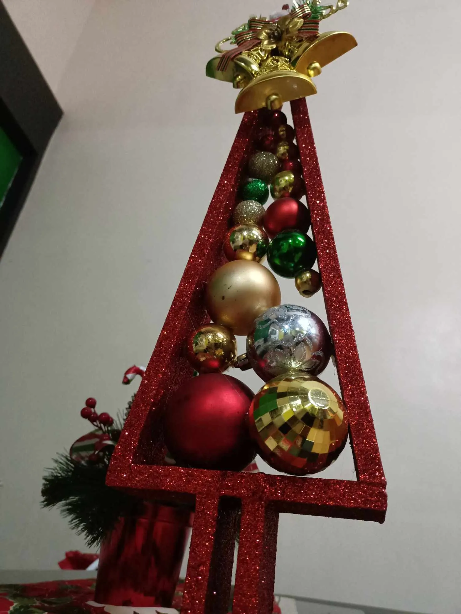 A little Christmas tree made of wood, carefully crafted with a rustic charm. The tree features small, colorful Christmas balls, adding a festive touch. Its natural wooden texture contrasts beautifully with the vibrant ornaments, creating a simple yet heartwarming holiday decoration. This miniature tree brings a cozy, handmade feel to the Christmas season.