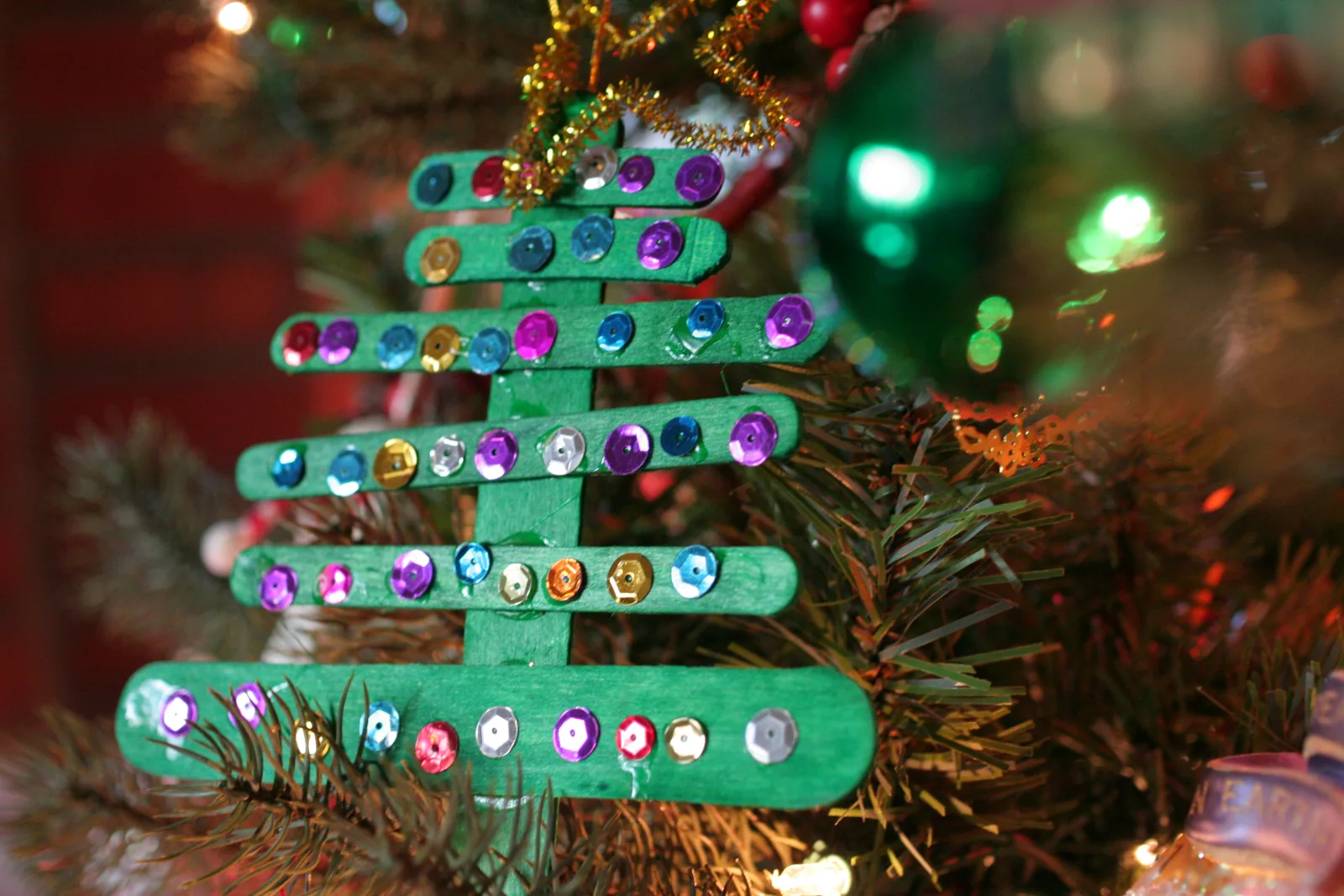 One of our Christmas traditions is to hang up handmade ornaments on the tree. This is one made by my son Aidan when he was 6 years old. He carefully picked out each one of the sparkly ornaments to glue on the popsicle stick tree. 

Details: Handheld, Tokina 35mm macro, SOOC