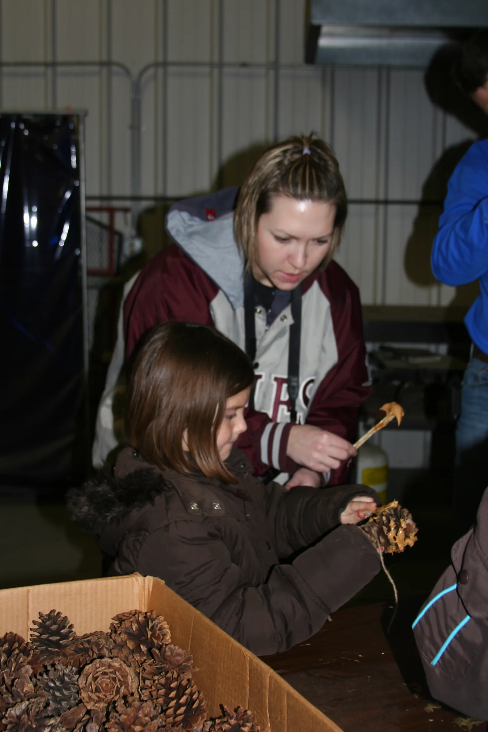 Making homemade bird feeders. These were made by puttting peanut butter all over the pine cones and then rolling the peanut butter covered pine cones in bird seed. 
Photo courtesy of Huron WMD