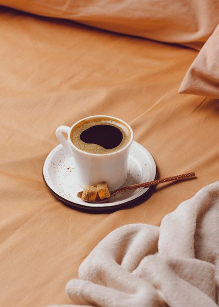 High angle of morning coffee cup on bed