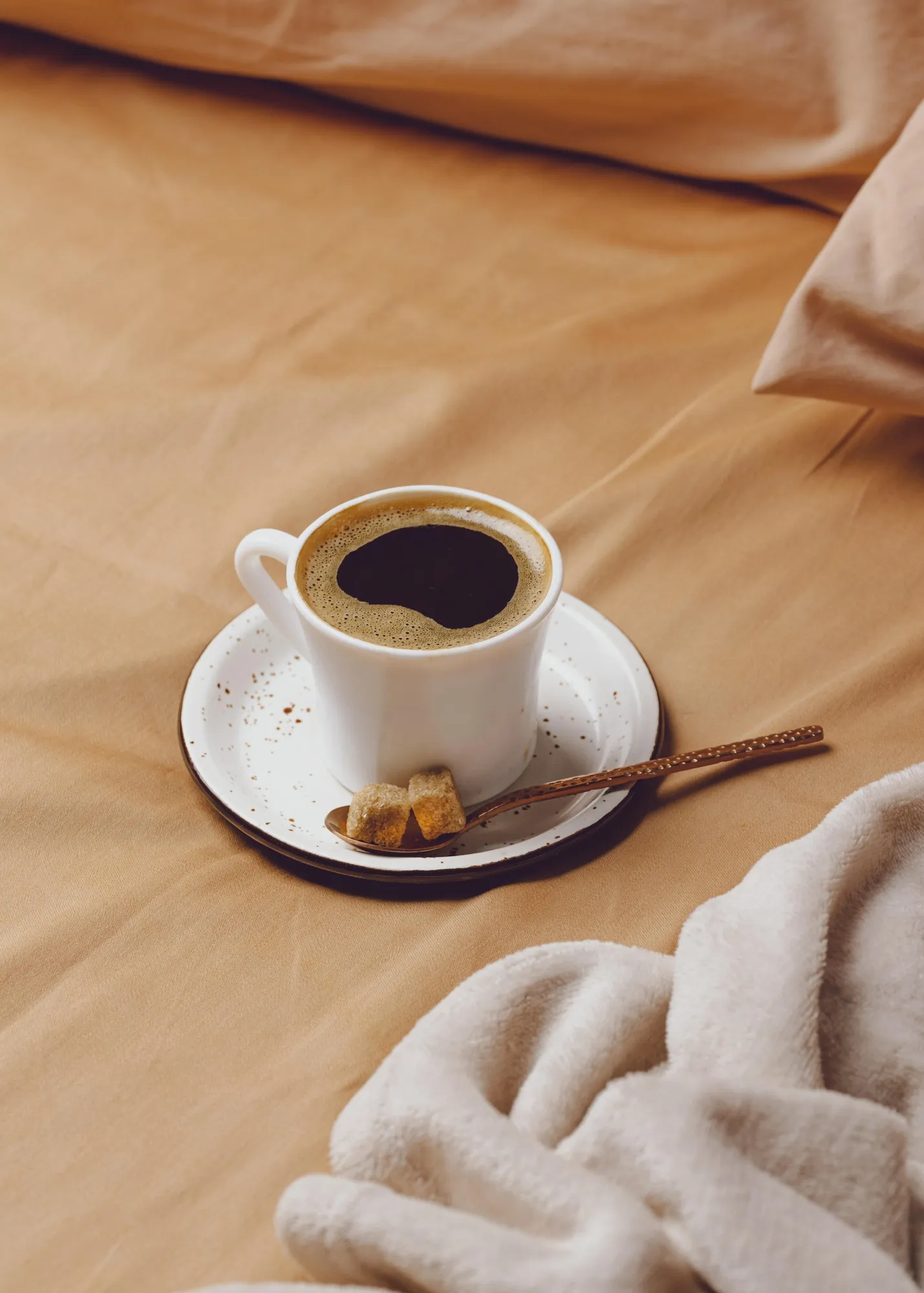 High angle of morning coffee cup on bed