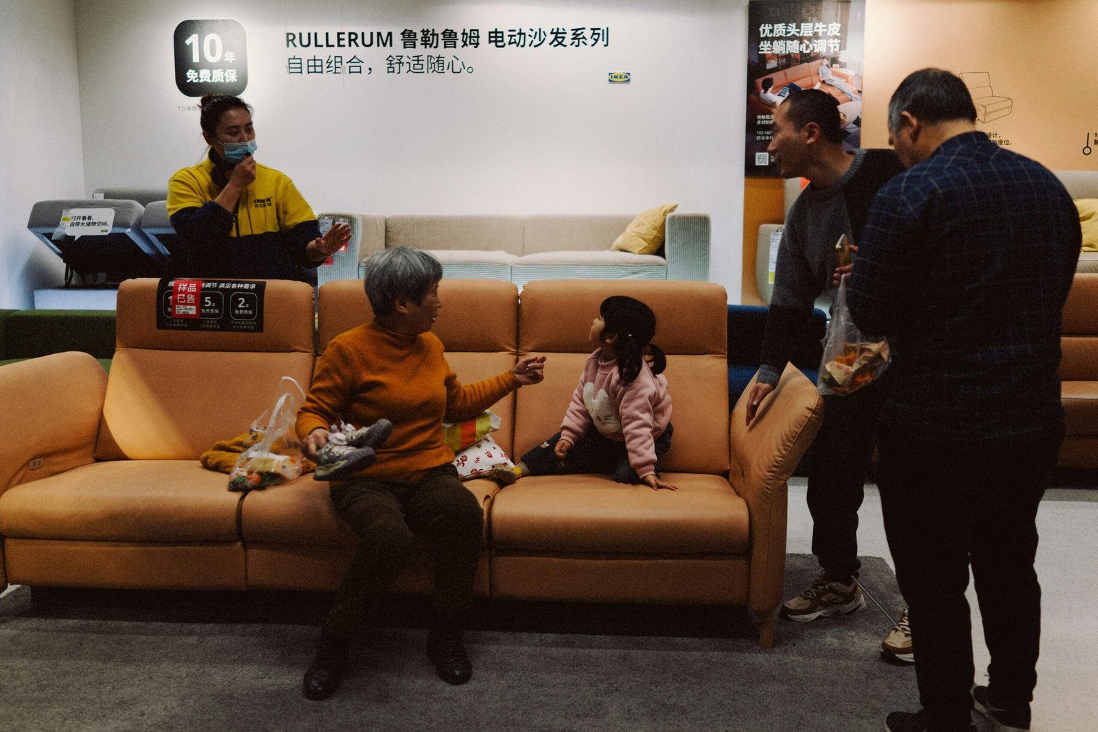People gathered around a sofa in a showroom.