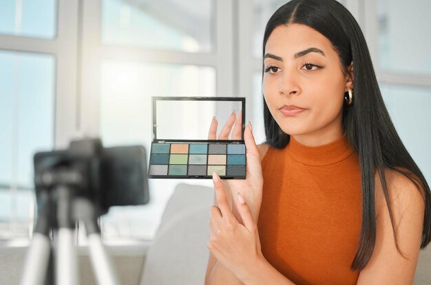 Live streaming makeup palette and woman on social media for content creation or filming on phone in home Influencer beauty cosmetics and recording video for teaching eyeshadow tutorial and tips