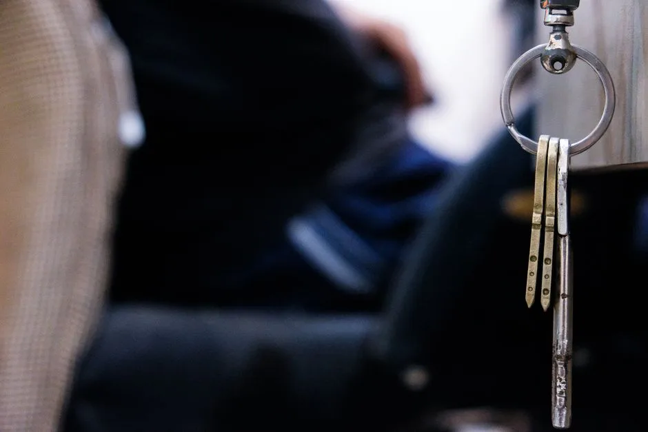 Detailed macro shot of metal keys hanging from a keychain indoors. Perfect for themes of security and lifestyle.